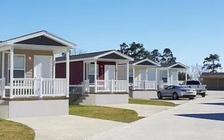 A row of mobile homes with front porches and steps leading to the entrance.