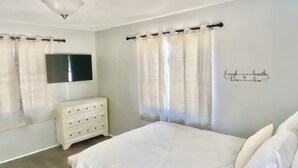 A bedroom with a bed, a dresser, a TV, and a wall with a motivational quote. - Orlando Spacious Home Near Universal (Orlando)