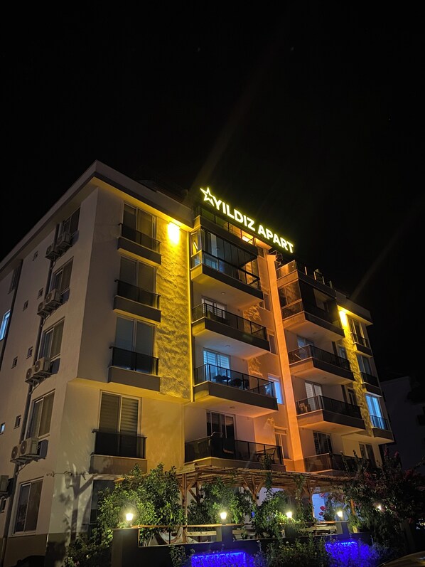 Un hotel de varios pisos con balcones y un letrero que dice "YILDIZ APART".