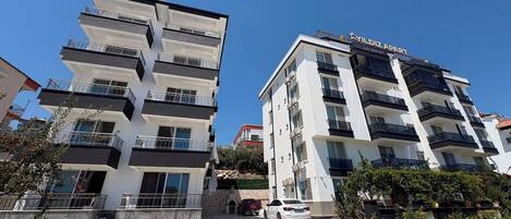 Un edificio a più piani con balconi e un cartello che riporta la scritta 'YILDIZ APART'.