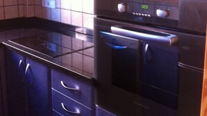 Una cocina con armarios azul oscuro, un microondas y un horno.