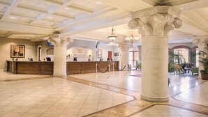 A spacious lobby with a reception desk, columns, and a chandelier. - Orlando | Pool & Disney Access | 4BR Sleeps 12 (Lake Buena Vista)