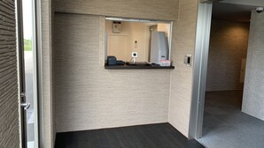 A modern bathroom with a dark wood floor, a mirror, a sink, and a small shelf with a basket.