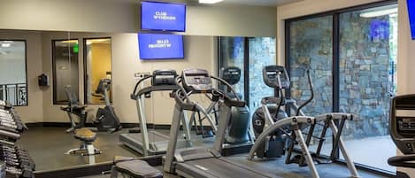 A gym with treadmills, elliptical machines, and free weights.