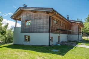 A modern two-story house with a sloped roof, wooden siding, and a small front porch.
