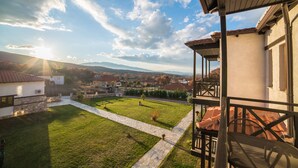 A residential area with a view of houses, a stone pathway, and a grassy lawn. - Paroraia boutique rooms (Sintiki)
