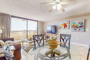 Relax in this stylish living room with a large dining table, comfortable sofa, and flat-screen TV.