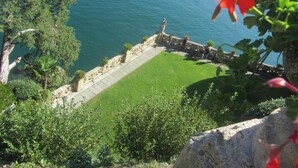 A coastal view with a stone pathway leading to a grassy area, overlooking the sea. - il balcone sul lago (Magreglio)