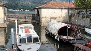 A boat docked at a harbor with a mountainous backdrop. - il balcone sul lago (Magreglio)