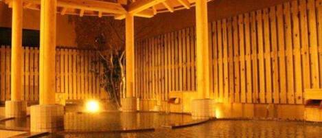 Un espace extérieur abrité comprenant une piscine, des colonnes en bois et une clôture.
