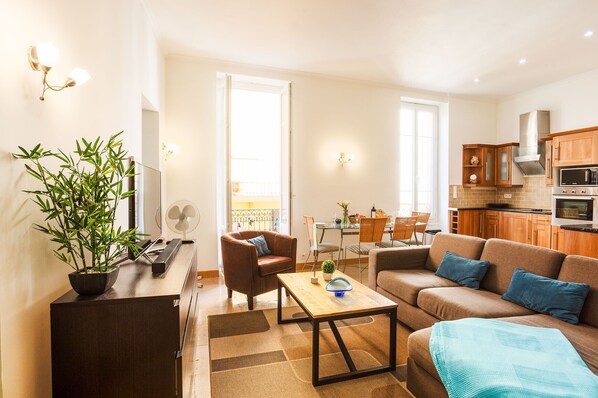 A modern living room with a sofa, coffee table, and a dining area with chairs and a table. - LA CITTA VECCHIA AP2021 by RIVIERA HOLIDAY HOMES (Villefranche-sur-Mer)