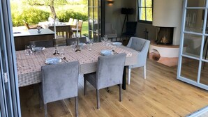 Een eethoek met een tafel gedekt voor vier personen, omringd door stoelen, en een open haard op de achtergrond.