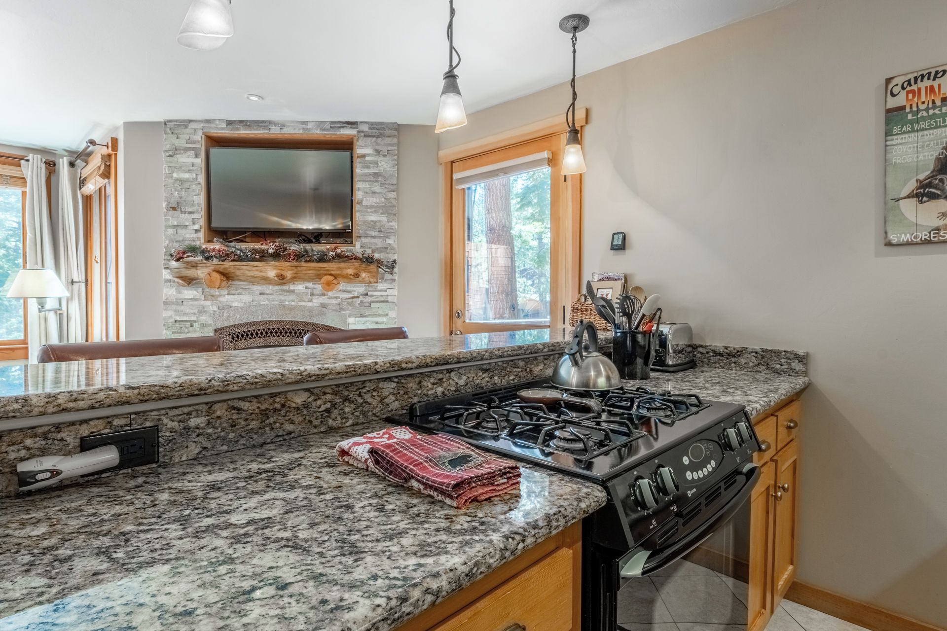 A kitchen with granite countertops, a built-in stove, and a stone backsplash.