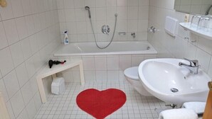 A bathroom with a bathtub, a sink, and a toilet.