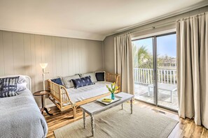 Relax in a cozy seating area with a sofa and armchair, perfect for reading or enjoying the view from the balcony.