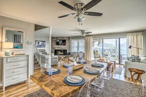Relax in a spacious living area with a dining table, sofa, and chairs, offering a view of the outdoors.