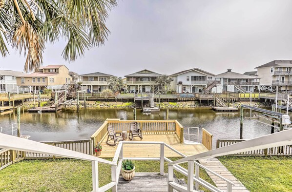 Enjoy the serene waterfront views from the balcony of this property, where a wooden deck offers a peaceful spot to unwind.