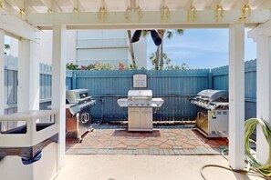 Enjoy al fresco dining with a barbecue setup under a shaded pergola.