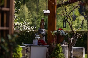 A garden with a wooden sculpture, a birdhouse, and a lantern. - Ferienwohnung Hochkalter, 2 bis 4 Personen, 82 qm (Schönau am Königssee)