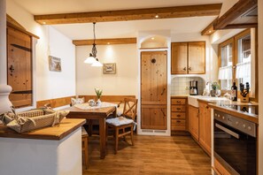 A cozy kitchen with wooden cabinets, a dining table, and a built-in oven.