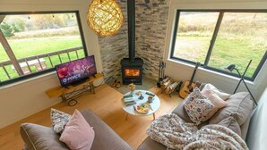 Una sala de estar acogedora con chimenea, televisor y un sofá cómodo.