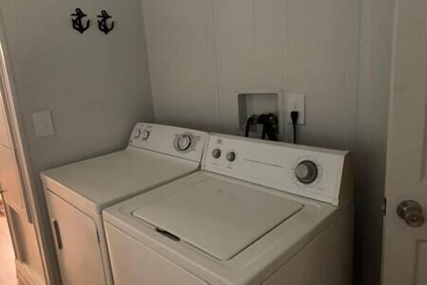 A laundry room with two stacked washing machines and a small electrical outlet on the wall. - "Cottage @ JP Coleman"-perfect getaway at Pickwick (Iuka)