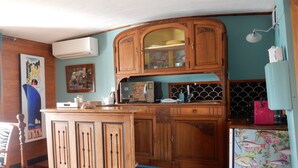 Une cuisine avec des meubles de rangement en bois, un four à micro-ondes et un réfrigérateur.