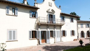 A building with a balcony, multiple windows, and a brick pathway. - Medieval castle turns into a Pool Villa and hosts Julia Roberts too. (Castelfiorentino)