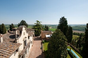 Una villa con patio, piscina y vistas al campo.