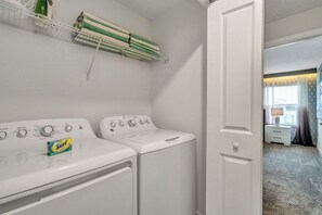A laundry area with two washing machines and a drying rack. - Glam 4BR Townhouse Themed Bedrooms & Resort Access (Kissimmee)