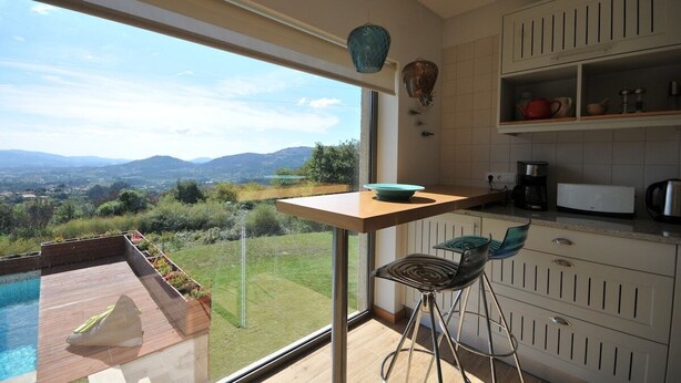Une cuisine moderne dotée d’une grande fenêtre donnant sur un paysage magnifique.