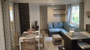 Un espace de vie compact comprenant un coin repas, un canapé et une kitchenette.