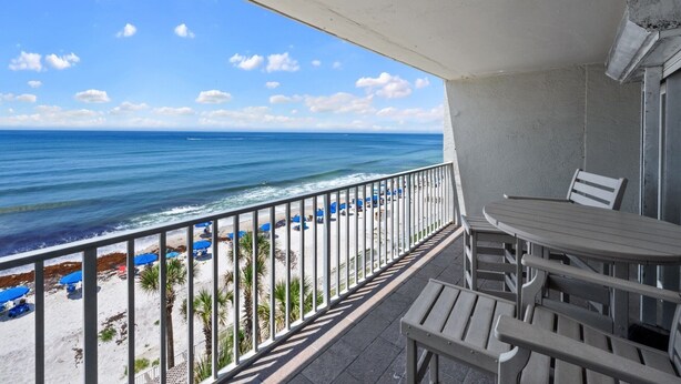 Un balcon avec vue sur la plage et l’océan.
