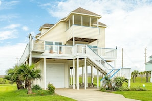 A two-story house with a balcony and a covered porch.