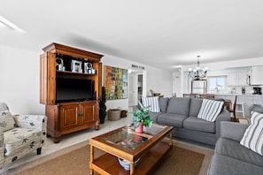 Relax in this stylish living room with a flat-screen TV, comfortable sofa, and dining area.