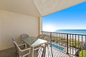 Enjoy the ocean view from this balcony with a glass-top table and two comfortable chairs.