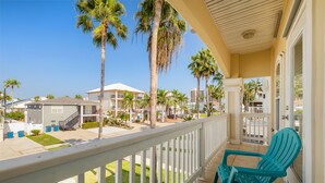 A balcony with a view of a residential area, including houses and palm trees.