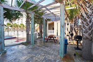 Enjoy al fresco dining on the patio, surrounded by palm trees and a barbecue grill.