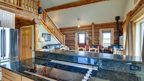 A kitchen with granite countertops, a stainless steel refrigerator, and a wooden staircase. - Creekside Log Cabin- conveniently located and direct creek access  (Buena Vista)