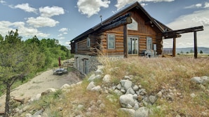 A log cabin with a stone foundation, a porch, and a view of the surrounding landscape. - Creekside Log Cabin- conveniently located and direct creek access  (Buena Vista)