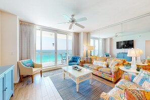 Relax in this ocean-view living room with a sofa, chair, and TV.