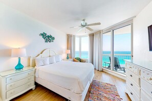 Enjoy ocean views from the large window and relax in the spacious room with a comfortable bed, nightstand, and dresser.