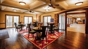 A spacious dining area with a high ceiling, exposed beams, and a view into the kitchen.