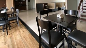 A spacious dining area with a wooden floor, a central table with chairs, and a staircase leading to an upper level. - Hotel Orla do Rio Branco (Boa Vista)
