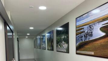 Un pasillo con suelo de baldosas y varias fotografías enmarcadas en la pared.