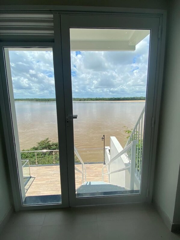 A room with a view of a river and a distant landscape.