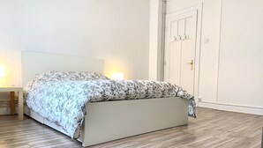 A bedroom with a bed, a bedside table, and a wardrobe. - Heart of Metz, 2 rooms free parking wifi 75m² "Le Saint Bernard (Metz)