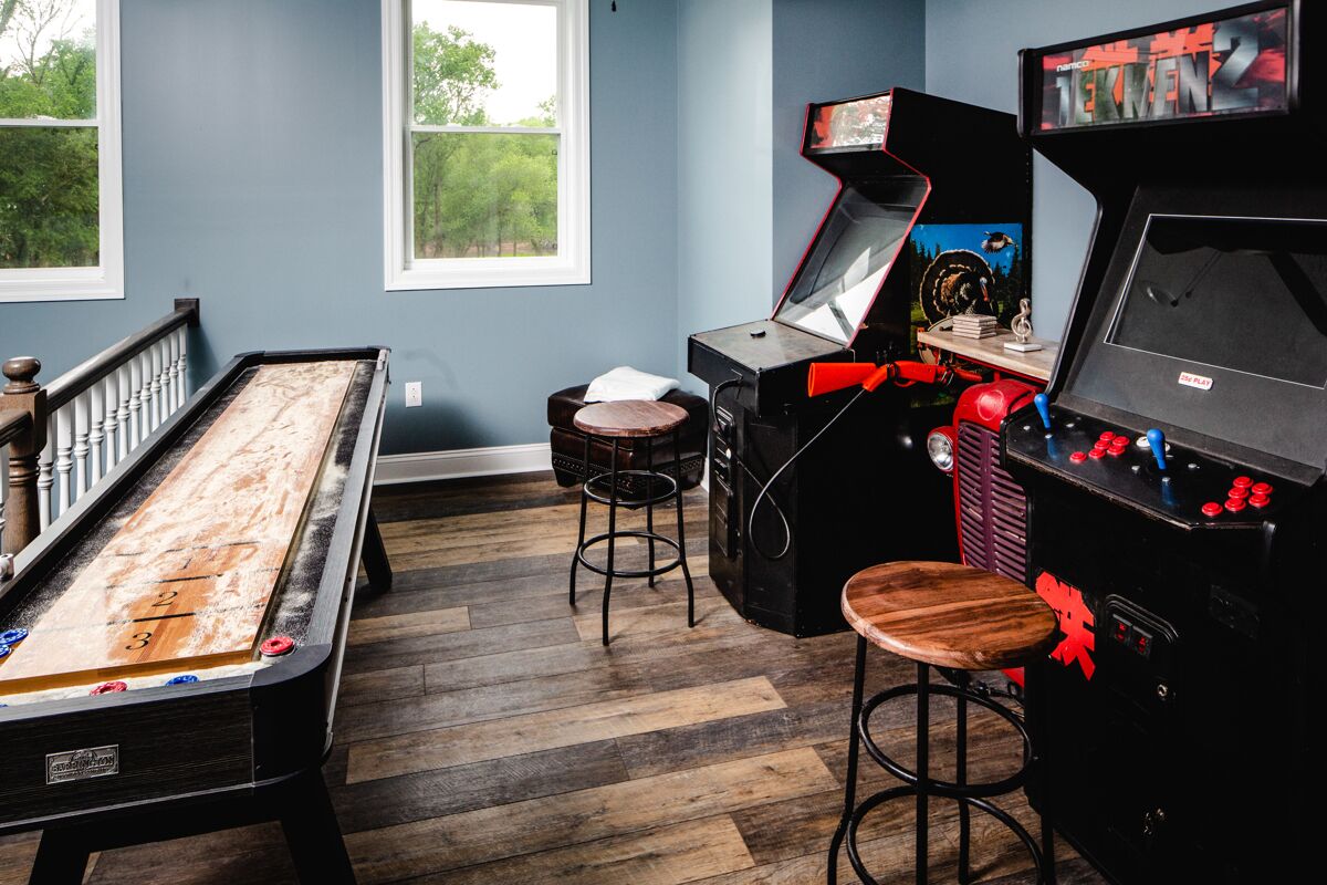 A pool table, stools, a bar area, and a view of the outdoors.