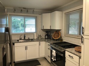 A kitchen with white cabinets, a stainless steel refrigerator, a built-in oven, and a gas stove. - HICKORY HOUSE 4 SHORT AND LONG TERM RENTAL (Hickory)