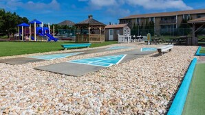 A playground with a slide, a gazebo, and picnic tables. - Sea Scape - Multiple Pools, Amenities, and Close to Beach! (Kitty Hawk)